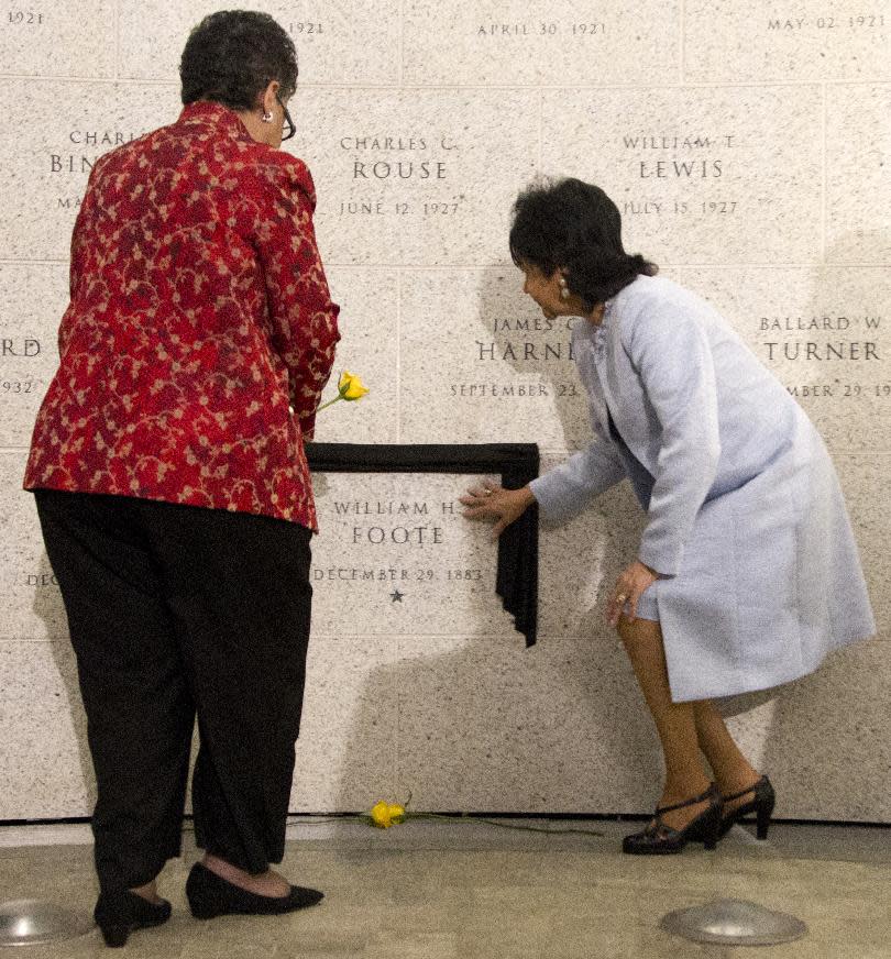 William Henderson Foote's great grand daughter Patricia Nolcox, right, and great grand niece Bettye Gardner, left, place flowers near the newly-unveiled on Bureau of Alcohol, Tobacco, Firearms and Explosives (ATF) Memorial Wall during a memorial ceremony to honor the first African American post-reconstruction era federal law enforcement officer killed in the line of duty, Monday, May 14, 2012, in Washington. The name of William Henderson Foote, a deputy collector with an ATF legacy agency, the U.S. Department of the Treasury, Bureau of Internal Revenue (BIR), was unveiled on ATFís Memorial Wall during an event commemorating National Police Week. Foote was killed Dec. 29, 1883, in Yazoo City, Miss., almost 130 years ago. (AP Photo/Manuel Balce Ceneta)