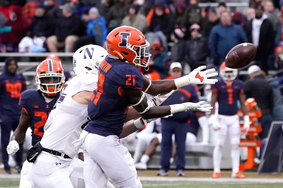 Illinois defensive back Jartavius Martin (21) incepts a pass intended for Northwestern wide receiver Will Lansbury during the first half of an NCAA college football game Saturday, Nov. 27, 2021, in Champaign, Ill. (AP Photo/Charles Rex Arbogast)