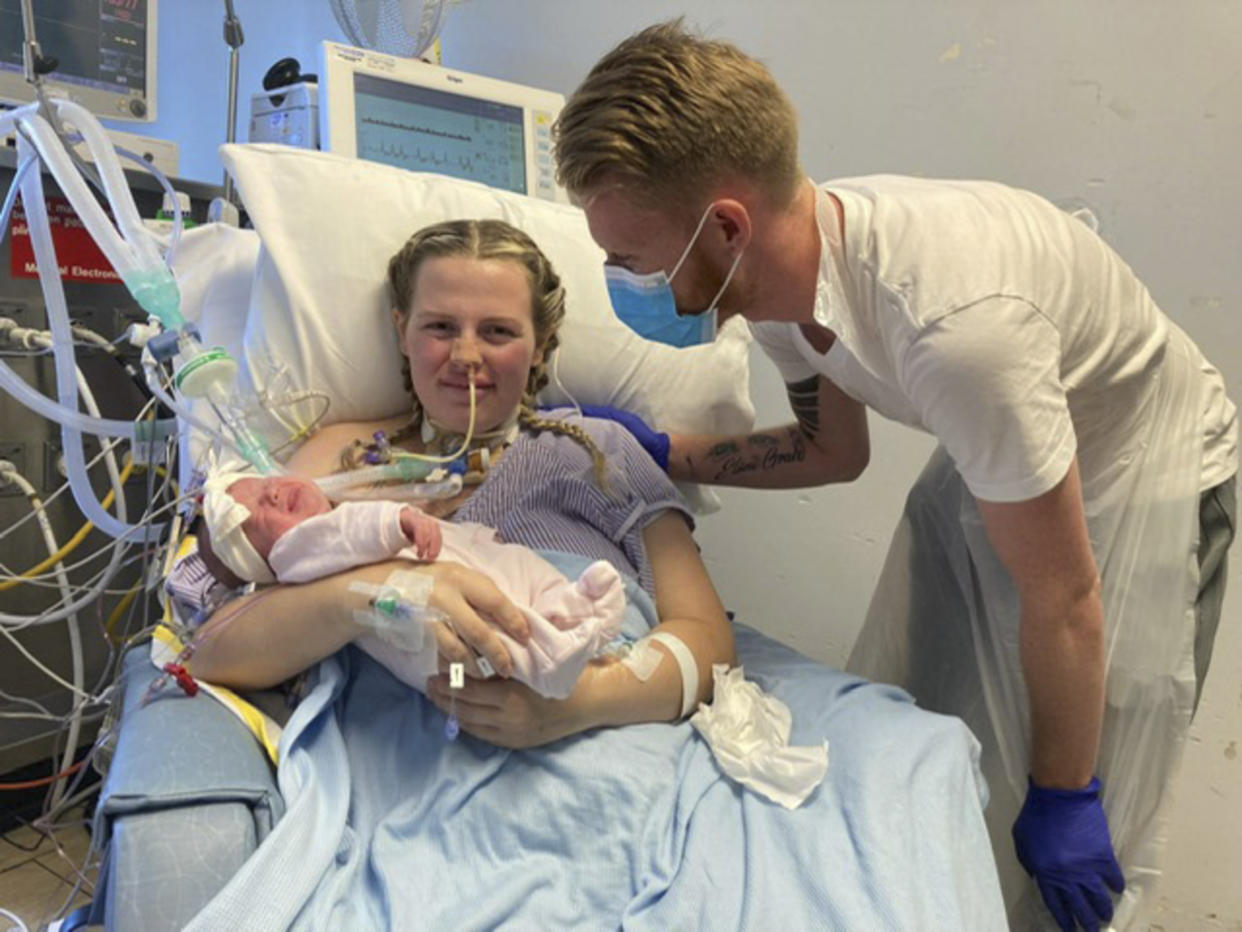 Mum Saskia Lane met her baby a month after giving birth, pictured with daughter Betsy, and partner, Lee Blackman. (Caters)