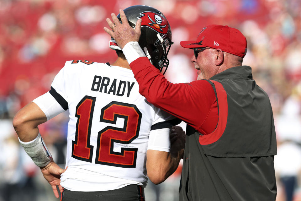 FILE - Tampa Bay Buccaneers coach Bruce Arians talks to quarterback Tom Brady before the team's NFL football game against the Carolina Panthers on Jan. 9, 2022, in Tampa, Fla. Arians has decided to retire as coach of the Buccaneers and move into a front-office role with the team, it was announced Wednesday night, March 30. Arians, who will turn 70 this coming season, coached the Bucs to the Super Bowl title in the 2020 season — Tom Brady’s first with Tampa Bay. (AP Photo/Mark LoMoglio, File)