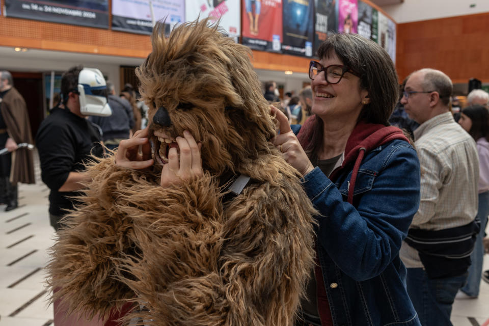 A woman helps her daughter put on a Chewbacca costume in Milan.