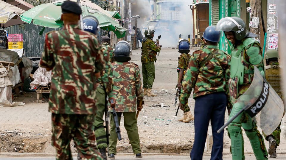 Riot police officer lobs teargas canisters to disperse supporters of Kenya's opposition leader. - Thomas Mukoya/Reuters