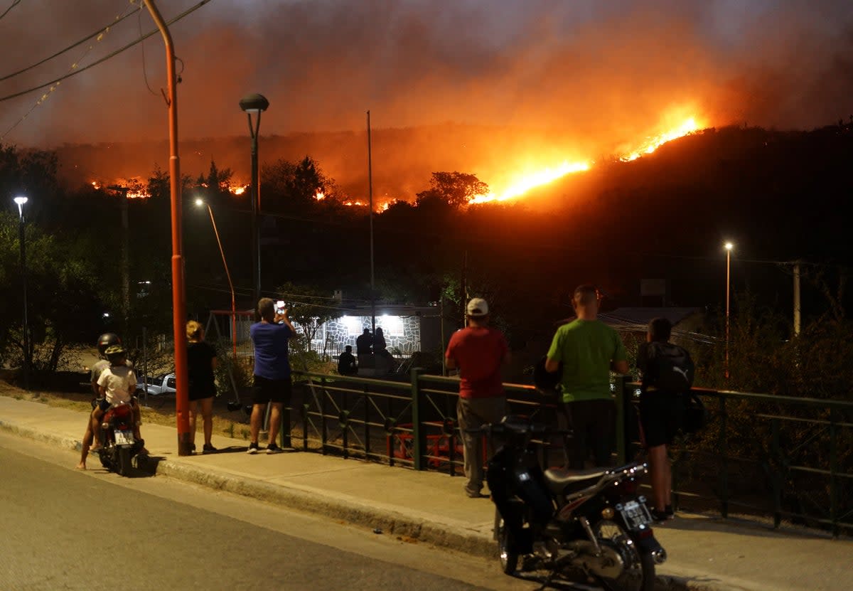 People look at a wildfire that has forced the evacuation of residents (Reuters)