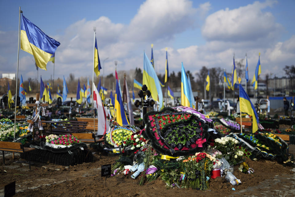 The grave of Yana Rikhlitska, 29, a Ukrainian army as a medic killed in the Bakhmut area, during the funeral in Vinnytsia, Ukraine, Tuesday, March 7, 2023. Just over a week ago, Yana Rikhlitska was filmed by The Associated Press as she helped treat wounded soldiers in a field hospital of Bakhmut area which has been pulverized as Russia presses a three-sided assault to seize it. (AP Photo/Thibault Camus)
