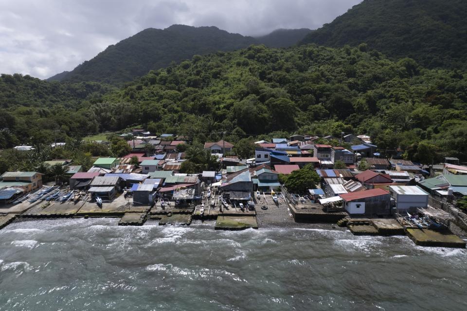 Small fishing boats are docked beside homes as waves batter the coastal village of Simlong in Batangas province, Philippines on Tuesday, Aug. 8, 2023. The Philippines is seeing one of the world's biggest buildouts of natural gas infrastructure. But the buildout raises serious questions about the health of nearby coral reefs and fishing communities. (AP Photo/Aaron Favila)