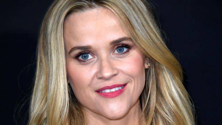 reese witherspoon smiling for a photo at a premiere event