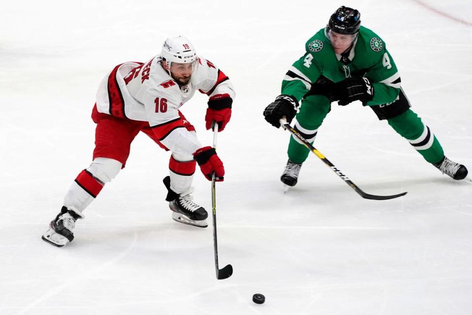 Carolina Hurricanes center Vincent Trocheck (16) makes a pass under pressure from Dallas Stars defenseman Miro Heiskanen (4) in the second period of an NHL hockey game in Dallas, Tuesday, April 27, 2021. (AP Photo/Tony Gutierrez)