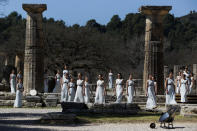 Actresses, playing the role of priestesses, performance during the flame lighting ceremony at the closed Ancient Olympia site, birthplace of the ancient Olympics in southern Greece, Thursday, March 12, 2020. Greek Olympic officials are holding a pared-down flame-lighting ceremony for the Tokyo Games due to concerns over the spread of the coronavirus. Both Wednesday's dress rehearsal and Thursday's lighting ceremony are closed to the public, while organizers have slashed the number of officials from the International Olympic Committee and the Tokyo Organizing Committee, as well as journalists at the flame-lighting. (AP Photo/Thanassis Stavrakis)