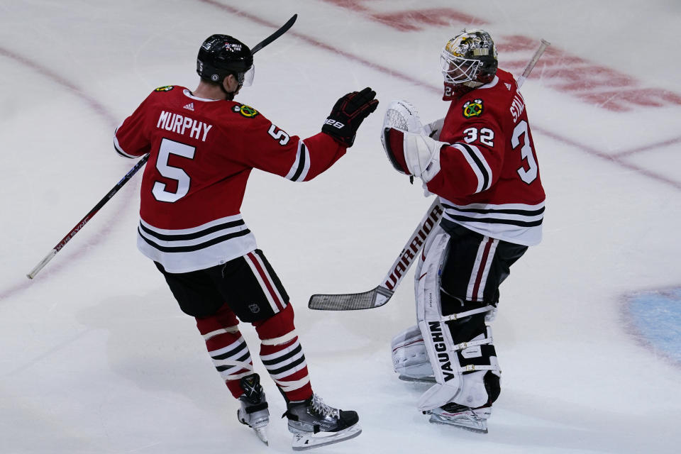 Chicago Blackhawks defenseman Connor Murphy, left, celebrates with goaltender Alex Stalock after they defeated the Seattle Kraken in an NHL hockey game in Chicago, Sunday, Oct. 23, 2022. (AP Photo/Nam Y. Huh)