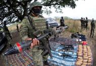 FILE PHOTO: A soldier holds up a seized grenade launcher after an operation at the village of Guayabal