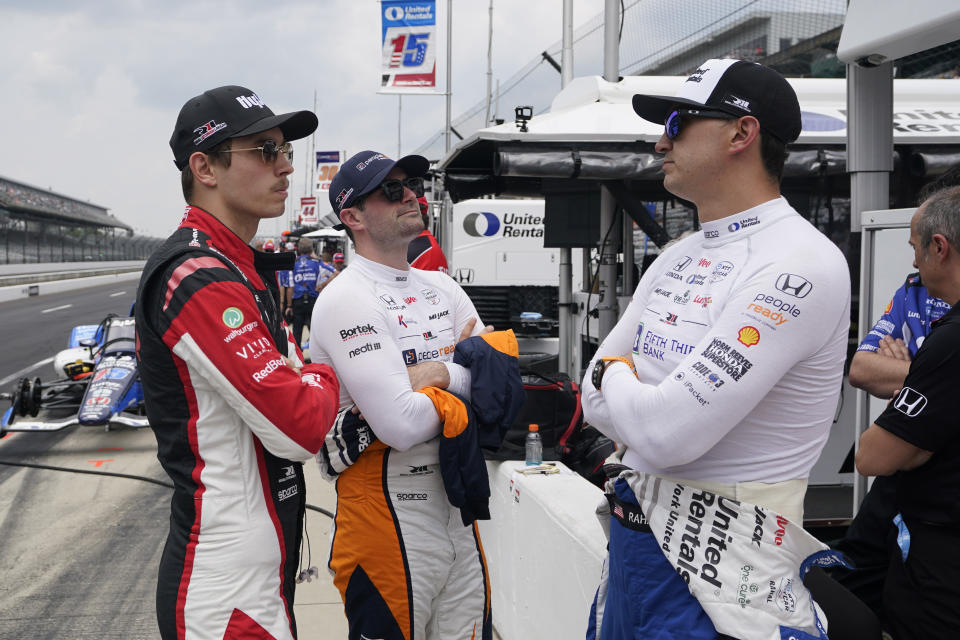 Christian Lundgaard, left, of Denmark, Jack Harvey, center, of England, and Graham Rahal talk during practice for the Indianapolis 500 auto race at Indianapolis Motor Speedway, Friday, May 19, 2023, in Indianapolis. (AP Photo/Darron Cummings)