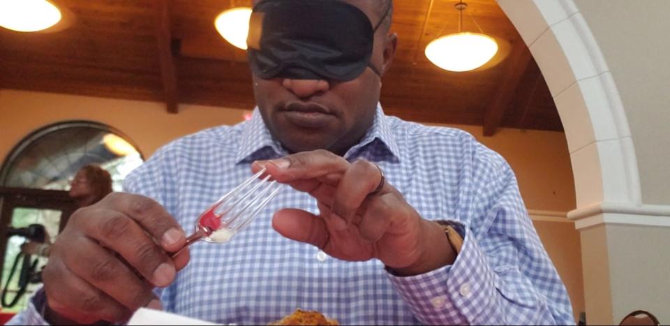 Myron Pitts eats blindfolded at a “Dining & Dialogue”  luncheon in the Orangery at the Cape Fear Botanical Garden. Attendees learned about resources offered by the Cape Fear Regional Vision Resource Center. The event was sponsored by Fayetteville-Cumberland Human Relations.