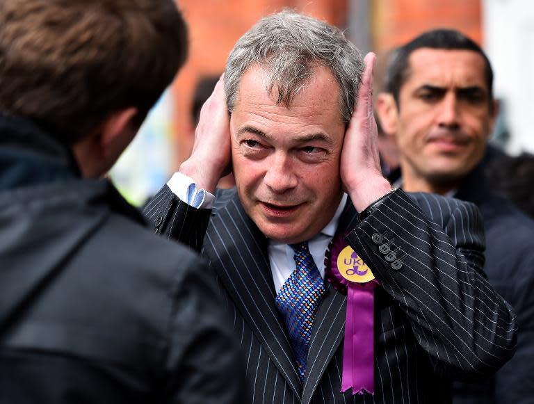 UKIP leader Nigel Farage covers his ears as he campaigns in Ramsgate in south east England on May 6, 2015