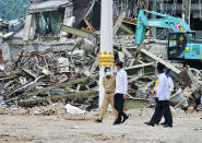 In this photo released by the Indonesian Presidential Palace, President Joko Widodo, center, talks to an official as he inspects an earthquake-damaged government building, in Mamuju, West Sulawesi, Indonesia, Tuesday, Jan. 19, 2021. Widodo visited the areas where a deadly earthquake left thousands of people homeless in an effort to reassure them the government's response is reaching those struggling after the quake. (Indonesian Presidential Palace via AP)