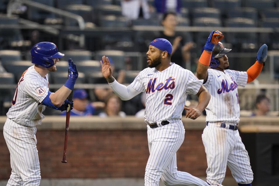 New York Mets' Dominic Smith (2) celebrates with Billy McKinney, left, and Francisco Lindor after scoring on a two-run single by Pete Alonso during the third inning of the team's baseball game against the Chicago Cubs on Tuesday, June 15, 2021, in New York. (AP Photo/Frank Franklin II)