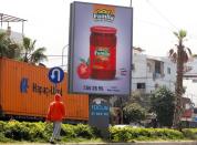 Man walks past an advertising billboard in Beirut suburbs