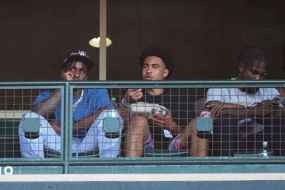 Carolina Panthers wide receiver Terrace Marshall Jr., quarterback Bryce Young and wide receiver Diontae Johnson, from left, watch a baseball game between the Los Angeles Angels and the Detroit Tigers, Thursday, June 27, 2024, in Anaheim, Calif. (AP Photo/Ryan Sun)