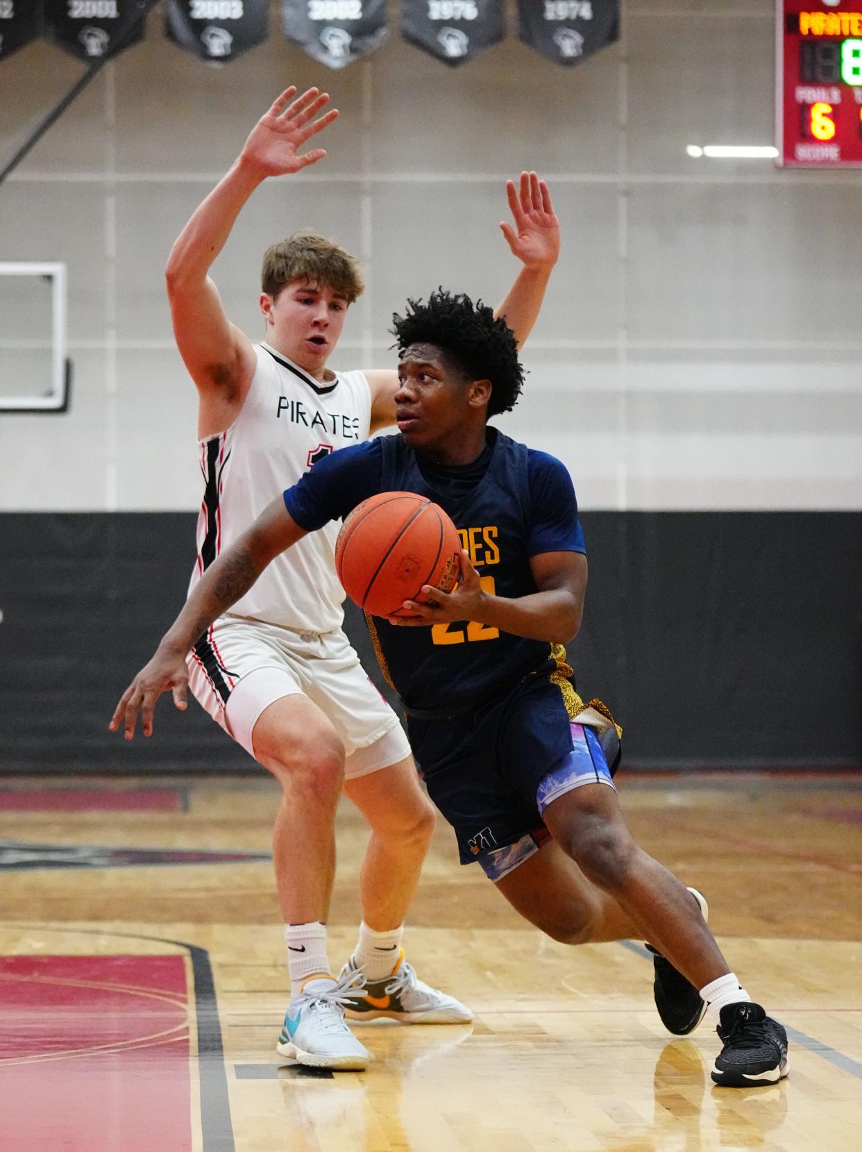 Pius XI's Jaquan Johnson (22) drives around Pewaukee's Owen Hake (1) during the game at Pewaukee, Thursday, Jan. 11, 2024.