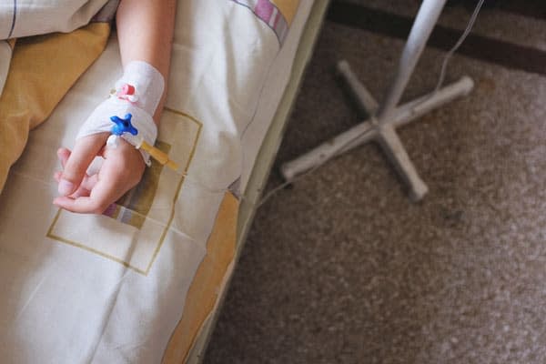 Child's hand with IV drip attached 