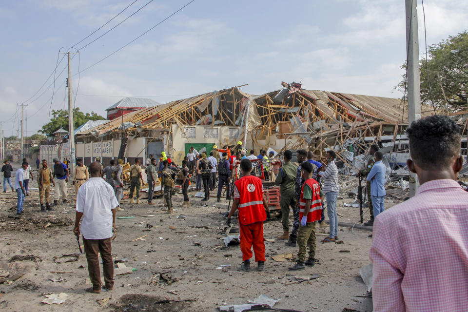 Security forces and rescue workers search for bodies at the scene of a blast in Mogadishu, Somalia Thursday, Nov. 25, 2021. Witnesses say a large explosion has occurred in a busy part of Somalia's capital during the morning rush hour. (AP Photo/Farah Abdi Warsameh)