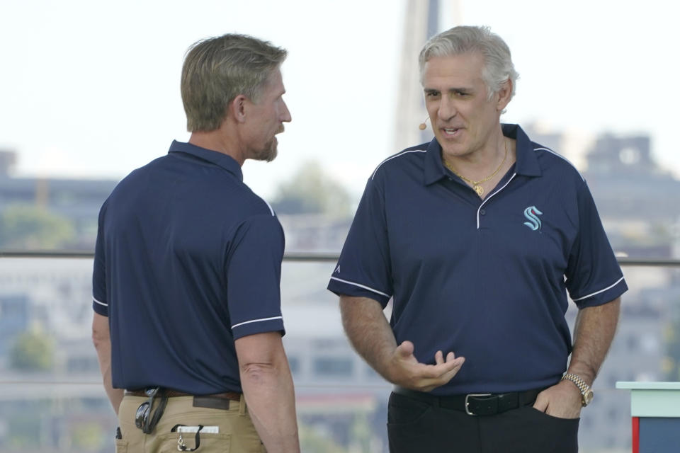 Seattle Kraken coach Dave Hakstol, left, talks with general manager Ron Francis on Wednesday, July 21, 2021, during the team's NHL hockey expansion draft event in Seattle. (AP Photo/Ted S. Warren)