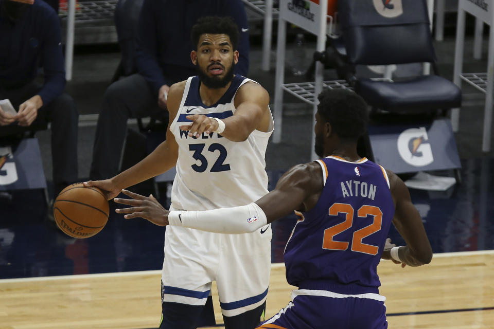 Minnesota Timberwolves's Karl-Anthony Towns (32) controls the ball against Phoenix Suns' Deandre Ayton (22) in the second half of an NBA basketball game Sunday, Feb. 28, 2021, in Minneapolis. (AP Photo/Stacy Bengs)