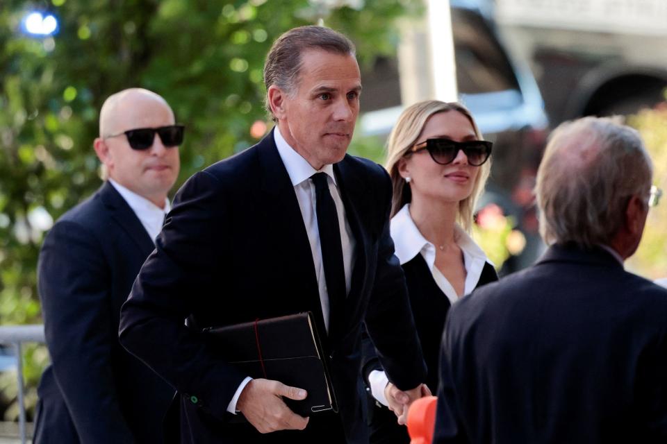 Hunter Biden, flanked by security and his wife, walks outside a courthouse in Wilmington, Delaware