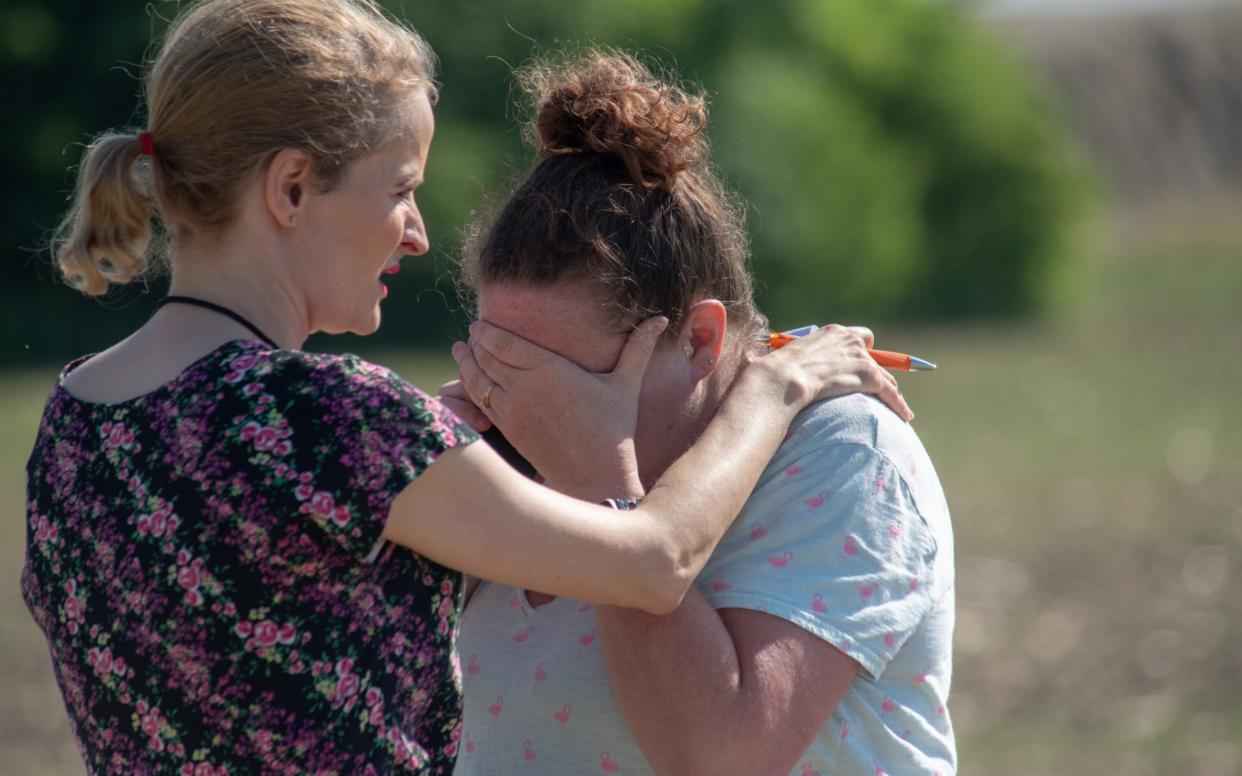 Substitute teacher Joanie Lynne, (L) consoles instructional assistant Paige Rose outside Noblesville West Middle School  - Getty Images North America