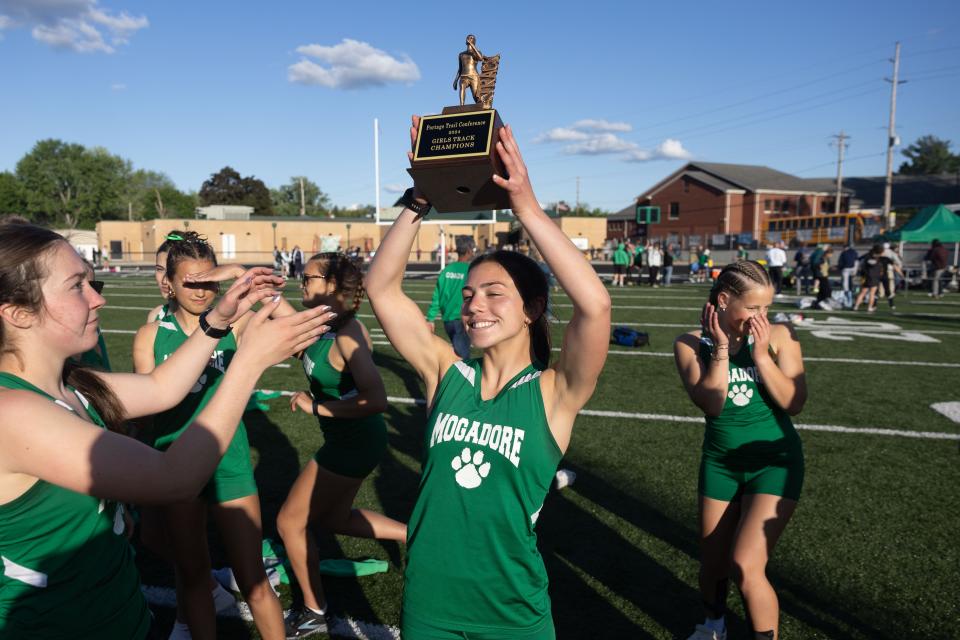 Mogadore senior Katie Lane hoists the 2024 Portage Trail Conference girls track & field championship trophy after the meet Friday, May 10, 2024.
