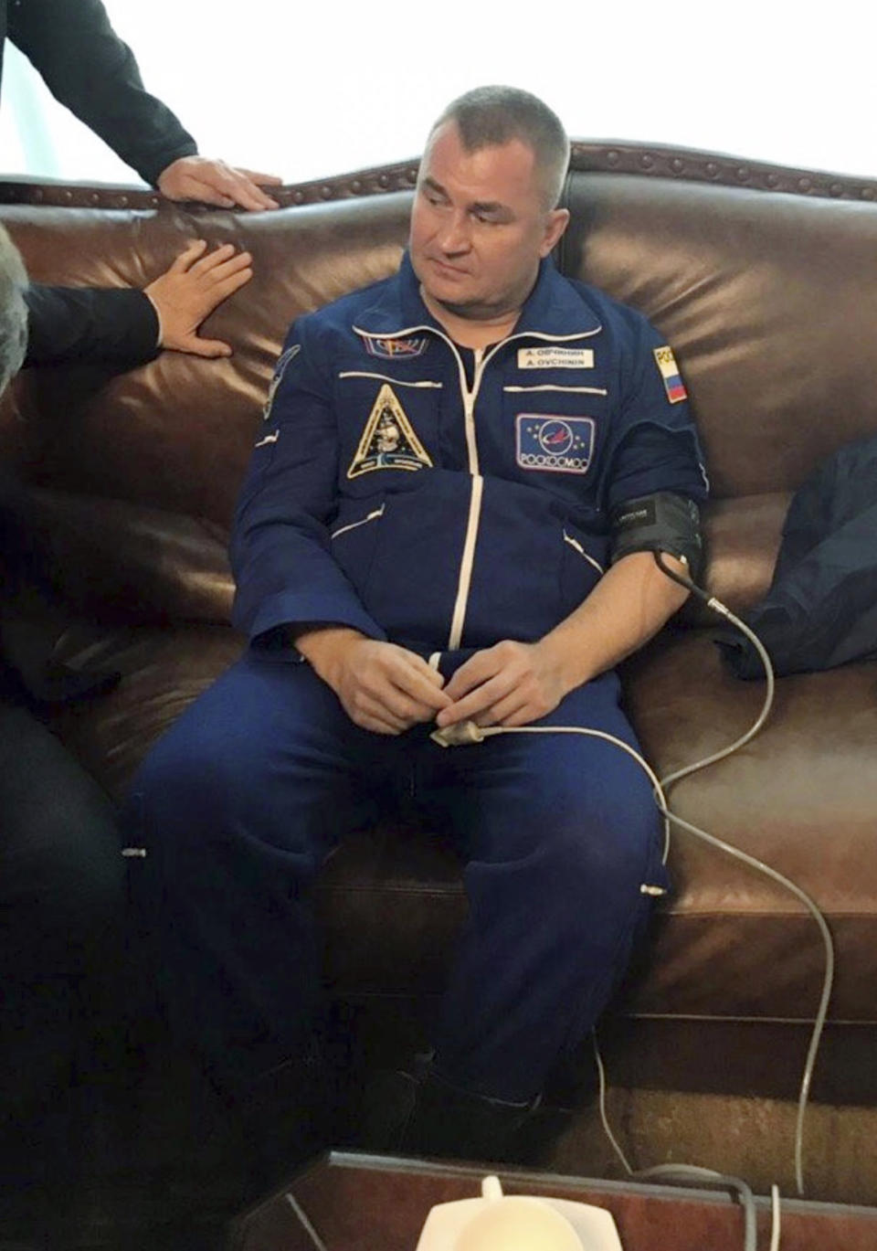 In this photo provided by Roscosmos, Russian cosmonaut Alexey Ovchinin sits in a hall after being transported by the rescue team, in Dzhezkazgan, about 450 kilometers (280 miles) northeast of Baikonur, Kazakhstan, Thursday, Oct. 11, 2018. Two astronauts from the U.S. and Russia were safe Thursday after an emergency landing in the steppes of Kazakhstan following the failure of a Russian booster rocket carrying them to the International Space Station. (Roscosmos via AP)