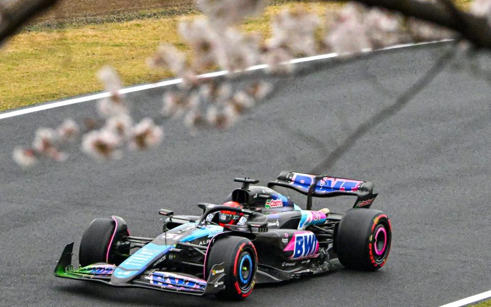 Alpine's French driver Esteban Ocon drives as he is seen passing cherry blossom trees during the second practice session ahead of the Japanese Grand Prix Formula One race at the Suzuka Circuit in Suzuka, Mie Prefecture on April 5, 2024