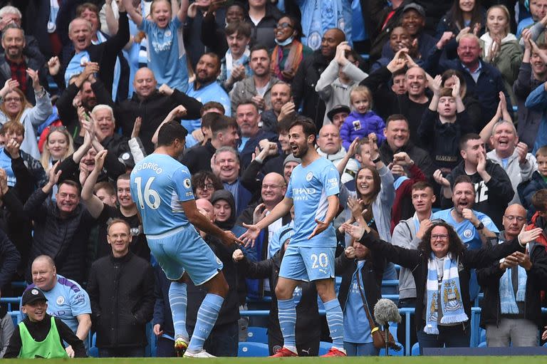 El centrocampista portugués del Manchester City Bernardo Silva (R) celebra el gol de apertura con el centrocampista español del Manchester City Rodrigo (L) durante el partido de fútbol de la Premier League inglesa entre el Manchester City y el Burnley