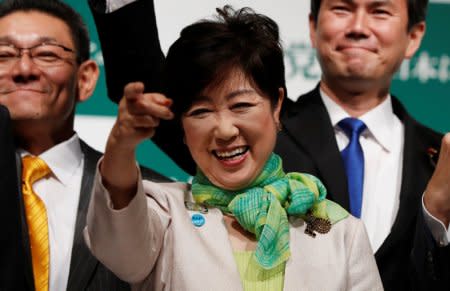 Tokyo Governor Yuriko Koike, the leader of her new Party of Hope, smiles as she raises her fist with her party members during a news conference to announce the party's campaign platform in Tokyo, Japan, September 27, 2017.   REUTERS/Issei Kato