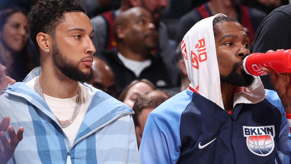 Ben Simmons and Kevin Durant sit side by side on the Brooklyn Nets' bench.