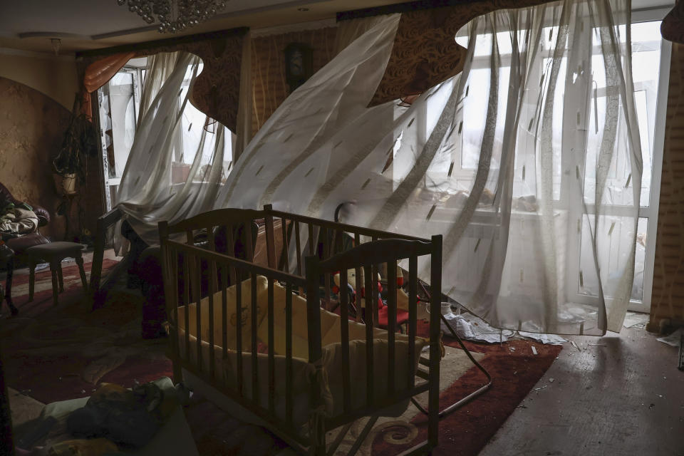 Curtains blow in a flat in the building damaged by shelling at the scene of the heaviest battles with Russian troops in Bakhmut, Donetsk region, Ukraine, Wednesday, March 15, 2023. (AP Photo/Roman Chop)