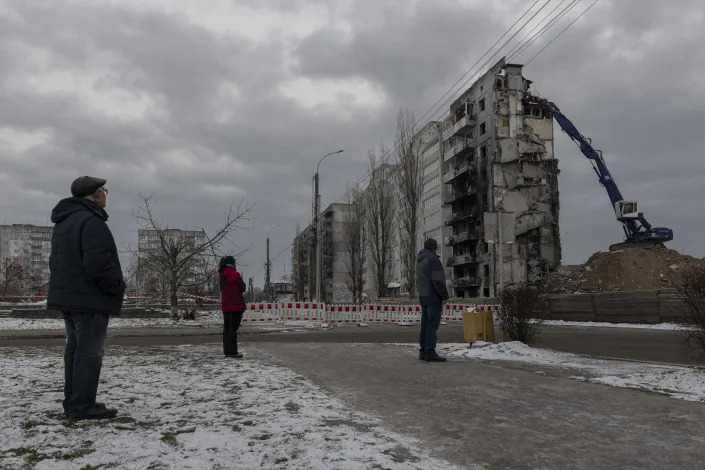 Local residents watch as a bombed building is dismantled in Borodyanka, Kyiv region, Ukraine, on Dec. 13. 