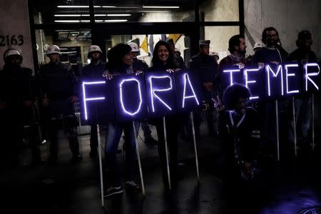 Demonstrators hold banners with led lights reading "Out Temer" in front of military police protest against Brazil's President Michel Temer in Sao Paulo, Brazil, May 18, 2017. REUTERS/Nacho Doce