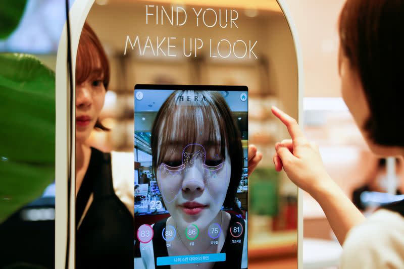 A woman shops using AR make up at a cosmetic shop in a department store in Seoul