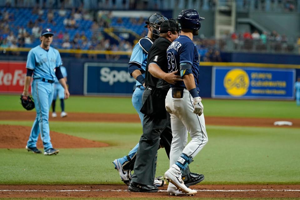 Rays outfielder Kevin Kiermaier is held back by home plate umpire Bruce Dreckman after he was hit by a pitch from Blue Jays pitcher Ryan Borucki, left, in their game on Wednesday.