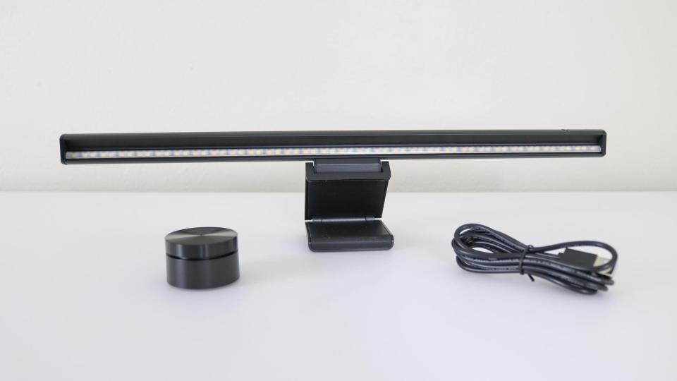 A monitor light bar along with its dial controller and USB-C cable