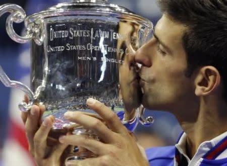 Novak Djokovic of Serbia kisses the U.S. Open trophy after defeating Roger Federer of Switzerland in their men's singles final match at the U.S. Open Championships tennis tournament in New York, September 13, 2015. REUTERS/Carlo Allegri