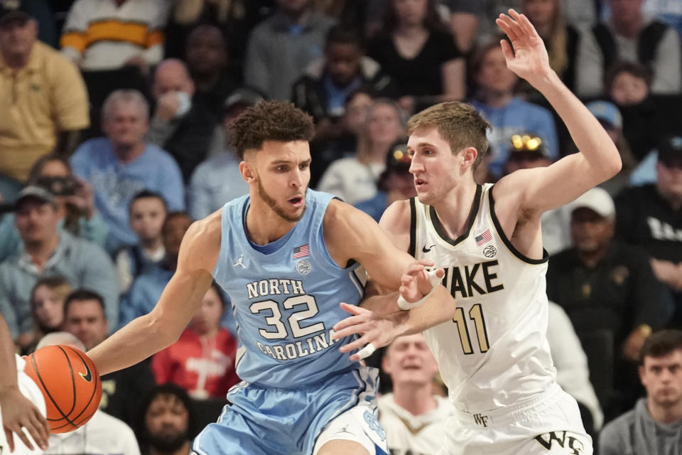 North Carolina forward Pete Nance (32) drives against Wake Forest forward Andrew Carr (11) during the first half of an NCAA college basketball game in Winston-Salem, N.C., Tuesday, Feb. 7, 2023. (AP Photo/Chuck Burton)