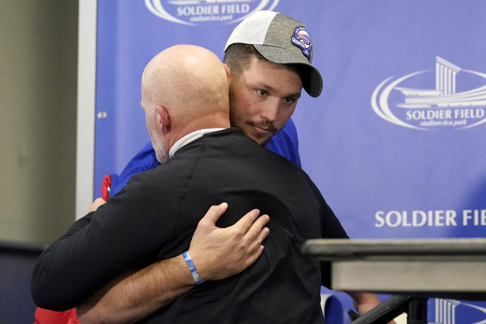 Buffalo Bills quarterback Josh Allen hugs head coach Sean McDermott as Allen arrives and McDermott departs a news conference after an NFL football game against the Chicago Bears Saturday, Dec. 24, 2022, in Chicago. The Bills won 35-13. (AP Photo/Charles Rex Arbogast)