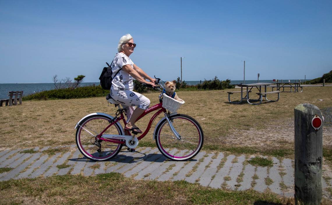 Niki Stevenson and her dog Missy tour Ocracoke by bicycle Wednesday, May 18, 2022. Bicycles and golf carts are the main modes of transportation on the island. Travis Long/tlong@newsobserver.com