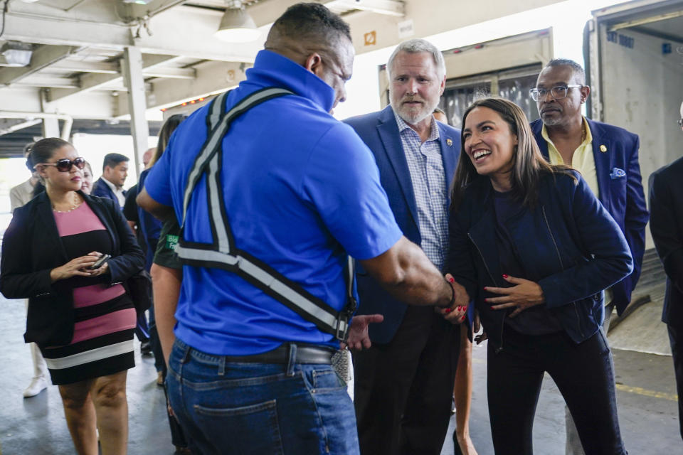 Rep. Alexandria Ocasio-Cortez, D-N.Y., right, greets one of the workers during a tour of the Hunts Point Produce Market with Teamsters Local 202 President Danny Kane, center, Thursday, July 7, 2022, in the Bronx borough of New York. As she seeks a third term this year and navigates the implications of being celebrity in her own right, she's determined to avoid any suggestion that she is losing touch with her constituents. (AP Photo/Mary Altaffer)