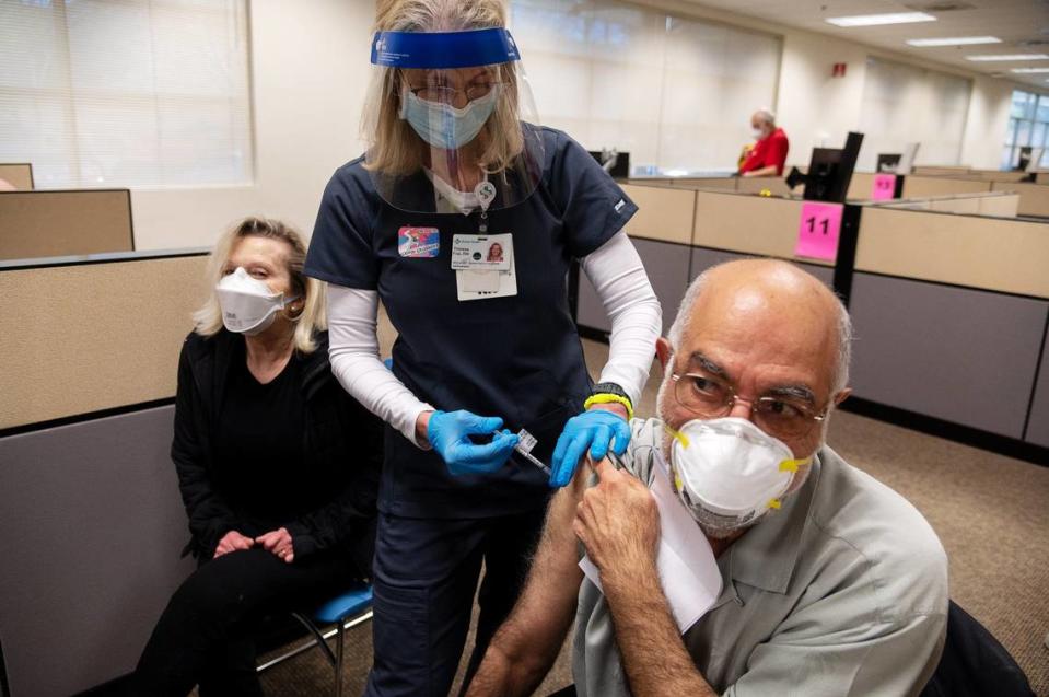 Registered nurse Theresa Frei, who is the chief executive officer of the Sutter Medical Foundation, administers the Pfizer COVID-19 vaccine to Nasser Kamili, 72, and Rebecca Kamdi, 66, during a large-scale vaccine clinic by Sutter Health on Thursday, Feb. 4, 2021 in Sacramento. Sutter is vaccinating 800 seniors and healthcare workers with their first doses of the vaccine.