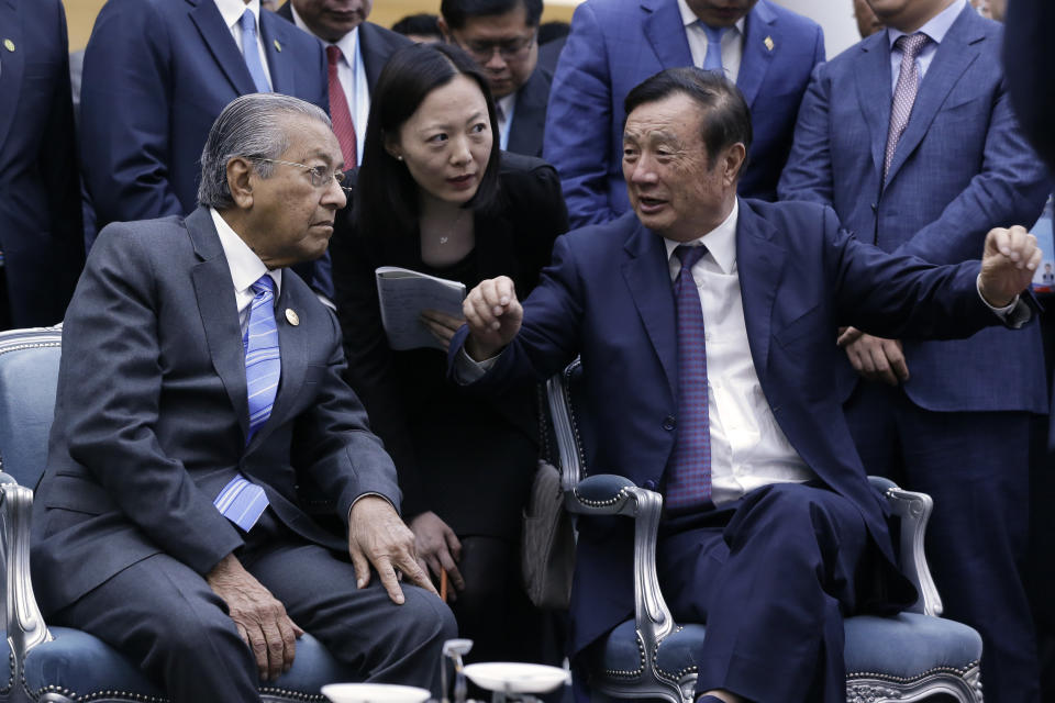 Huawei founder and CEO Ren Zhengfei, right, explains the 5G network system to Malaysian Prime Minister Mahathir Mohamad, left, as Mahathir visits to Huawei Executive Briefing Center in Beijing, Thursday, April 25, 2019. Mahathir is in Beijing to attend the Belt and Road Forum which start on this weekend. (AP Photo/Andy Wong)