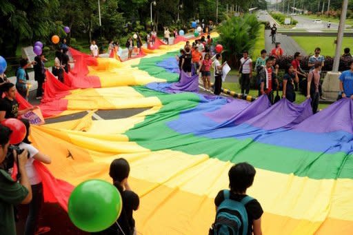 Supporters of lesbian, gay, bisexual, and transgender (LGBT) groups hold a huge rainbow banner as they march at the University of the Philippines (UP) campus in Manila in June 2012. The Philippines is is facing a HIV epidemic, with sex between men making up nearly 90 percent of all new cases, according to the health department and the United Nations' Development Programme (UNDP)