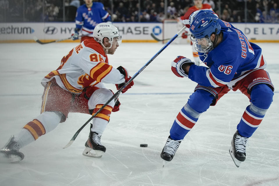 Calgary Flames left wing Andrew Mangiapane (88) skates against New York Rangers defenseman Erik Gustafsson (56) during the first period an NHL hockey game XXX on Monday, Feb. 12, 2024, in New York. (AP Photo/Bryan Woolston)