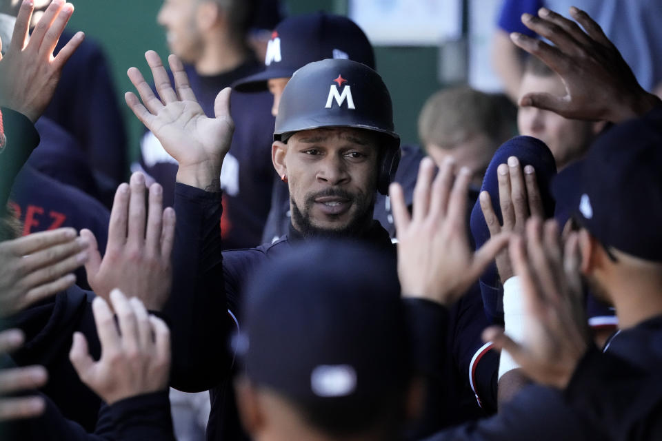 Minnesota Twins' Byron Buxton celebrates in the dugout after scoring on a single by Jose Miranda during the first inning of a baseball game against the Kansas City Royals Saturday, April 1, 2023, in Kansas City, Mo. (AP Photo/Charlie Riedel)